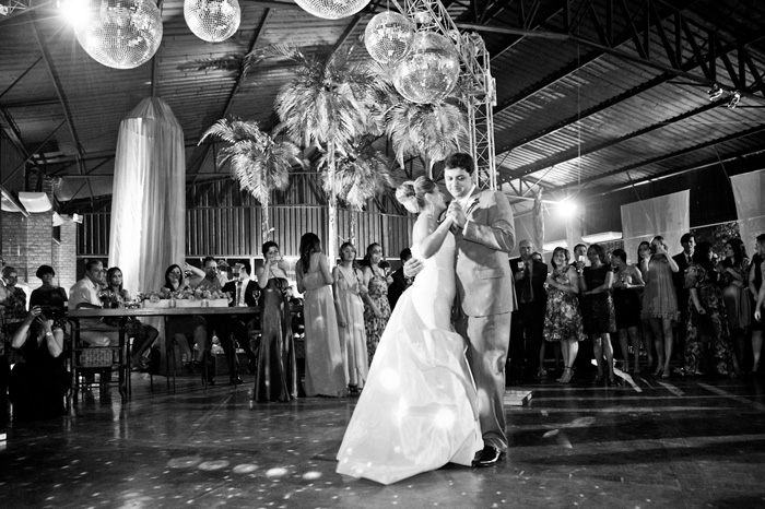 Noivos dançando sob bolas de espelho em casamento